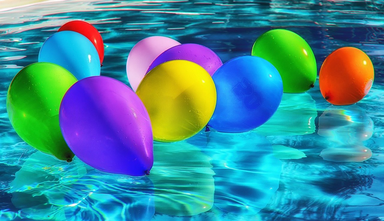Brightly coloured balloons in pool