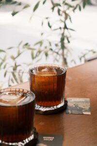 a glass of tea sitting on top of a wooden table
