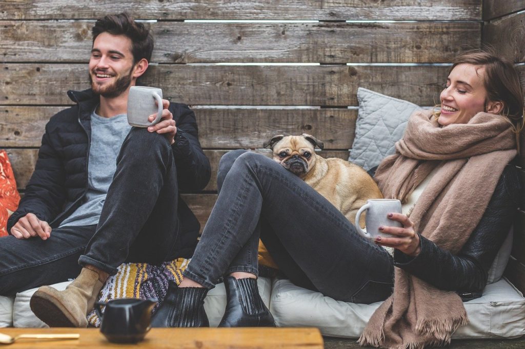 happy couple with coffee and pug