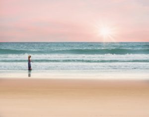 woman walking on beach sunset